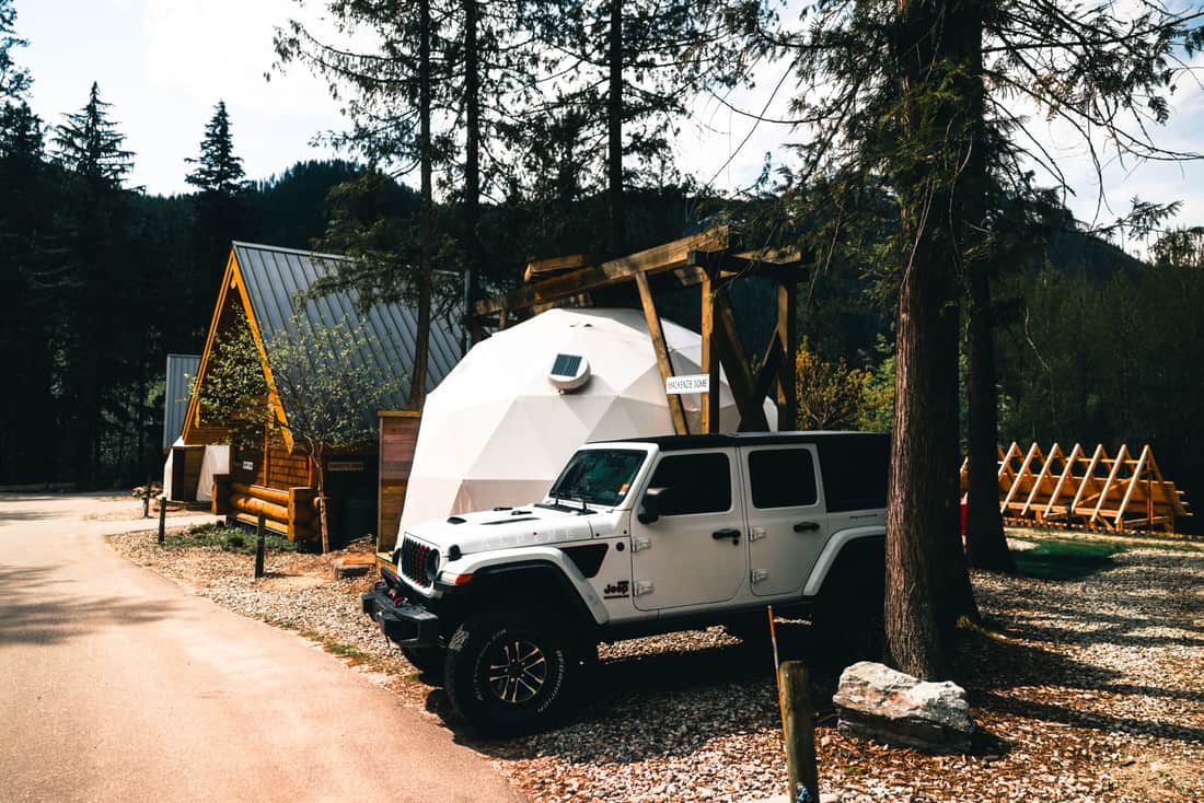 A vehicle loaded with gear parked at the start of a trail