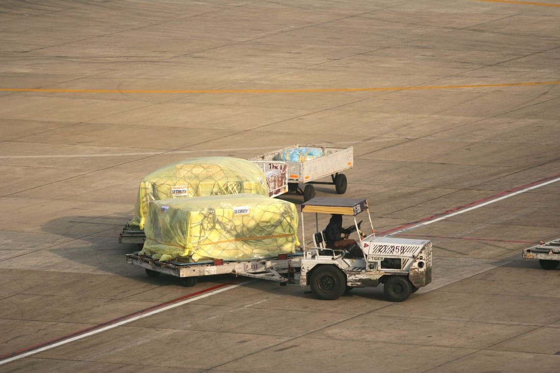 A ratchet strap being tightened over a secured load