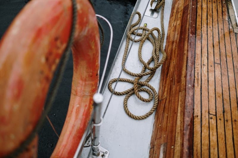 Representative photo of a webbing cam strap coiled beside a boat